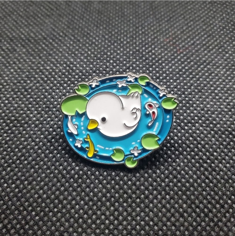 baby duck in a koi pond enamel pin. very cute and detailed enamel pin.